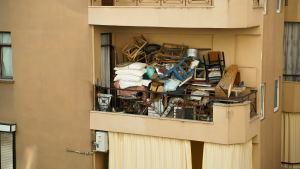 Balcon encombré par du mobilier et diverses affaires nécessitant un nettoyage extrême